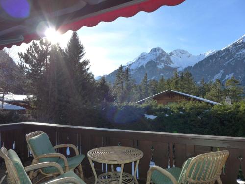 a table and chairs on a balcony with a view of mountains at Holiday Home Chalet Marietta by Interhome in Kandersteg