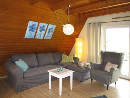 Holiday Home Ferienhäusle Nina by Interhome في Wilhelmsdorf: غرفة معيشة مع أريكة وكرسيين