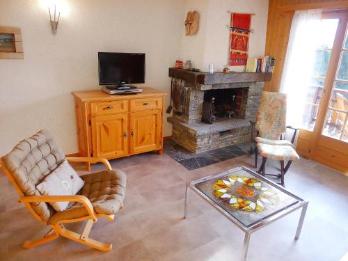 a living room with a television and a fireplace at Apartment Sapin Bleu 5 by Interhome in Villars-sur-Ollon