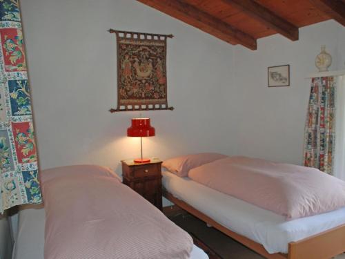 a bedroom with two beds and a lamp on a table at Apartment Casa tre G - App OG by Interhome in Losone