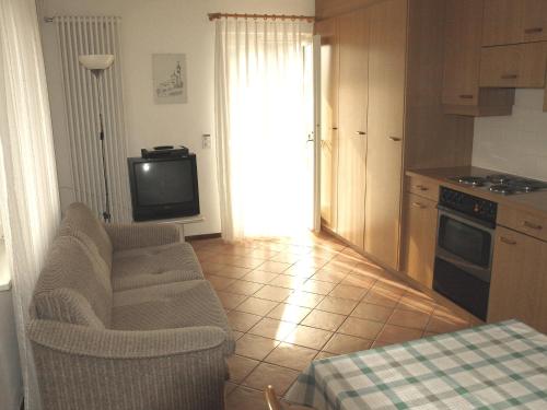 a kitchen with a couch and a tv in a room at Apartment al Ronchetto by Interhome in Carona