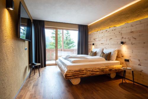 Hotel Mont Floris Obereggen في أوبيريجّين: غرفة نوم بسرير ونافذة كبيرة