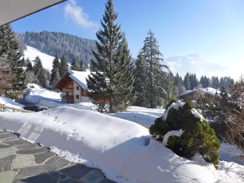 een berg sneeuw voor een huis bij Apartment Armorial II - apt 2 by Interhome in Villars-sur-Ollon