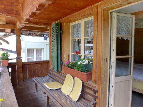 un porche de una casa con 2 sillas y una ventana en Apartment Grosshorn by Interhome en Lauterbrunnen