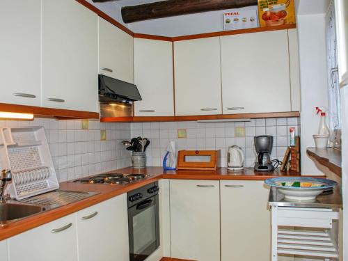 a kitchen with white cabinets and a counter top at Holiday Home La Rustica by Interhome in Brione