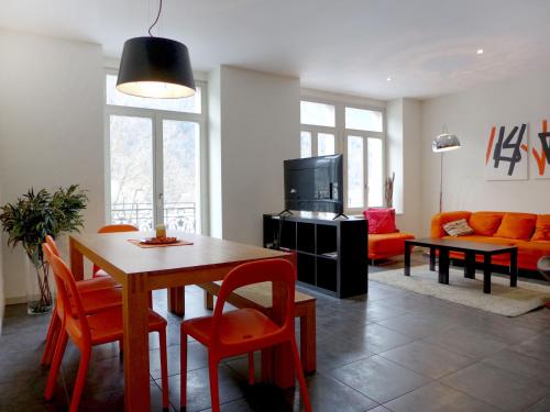 ein Wohnzimmer mit einem Tisch, Stühlen und einem Sofa in der Unterkunft Apartment Modern by Interhome in Interlaken
