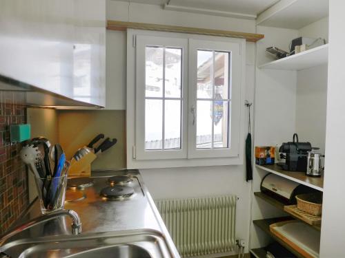 eine Küche mit einem Waschbecken und einem Fenster in der Unterkunft Apartment Chalet Seeberg by Interhome in Lenk im Simmental