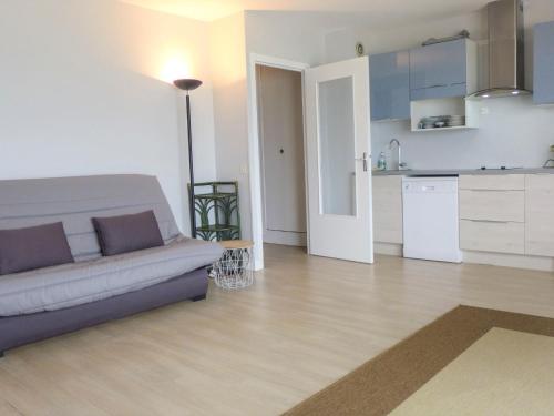 a living room with a couch and a kitchen at Apartment Isabelle-1 by Interhome in Cabourg