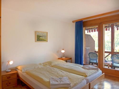 ein Schlafzimmer mit einem Bett und einem großen Fenster in der Unterkunft Apartment Rose Studio Y by Interhome in Wengen
