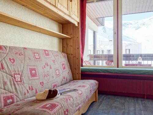 Un sofá sentado en una habitación con ventana. en Apartment Le Prariond - Val Claret-6 by Interhome, en Tignes