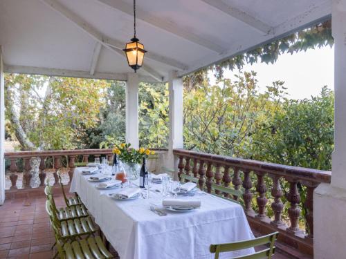 - une table à manger sur une terrasse couverte avec un chiffon de table blanc dans l'établissement Holiday Home Villa Jaume by Interhome, à Le Racou