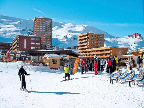 a group of people on skis in the snow near buildings at Apartment Plagne Centre 3 - LAP173 by Interhome in La Plagne