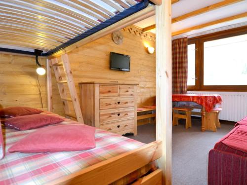 a bedroom with two beds and a tv in a cabin at Apartment Plagne Centre 3 - LAP173 by Interhome in La Plagne