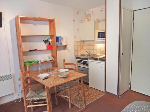 una pequeña cocina con mesa de madera y sillas en Apartment L'Astragale-1 by Interhome en Les Menuires