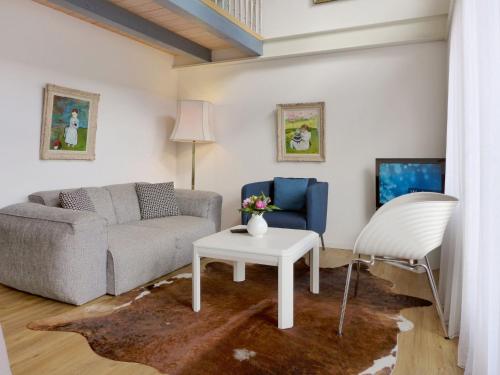 ein Wohnzimmer mit einem Sofa und einem Tisch in der Unterkunft Studio Galeriestudio Jungfraublick by Interhome in Interlaken