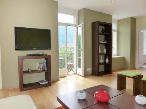 ein Wohnzimmer mit einem Flachbild-TV an der Wand in der Unterkunft Apartment Elegance by Interhome in Interlaken