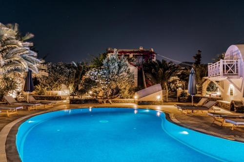 a swimming pool in front of a house at night at Marillia Village in Perivolos