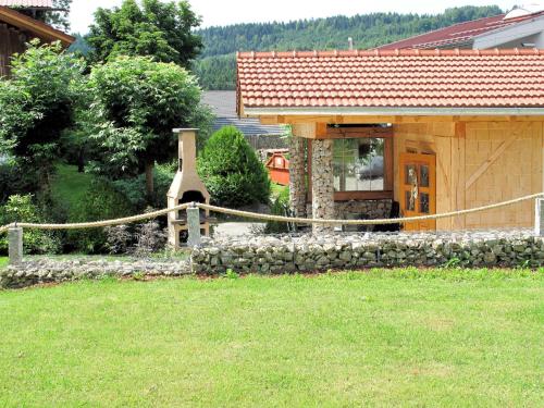a house with a stone wall in front of a yard at Holiday Home Triendl by Interhome in Bischofsmais