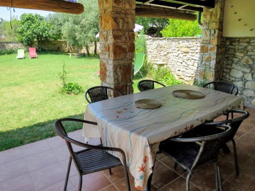 ein Tisch mit Stühlen und ein Tischtuch auf einer Terrasse in der Unterkunft Holiday Home Nadija - PUL428 by Interhome in Vodnjan