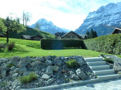 a rock garden with mountains in the background at Apartment Chalet Schwendihus-6 by Interhome in Grindelwald