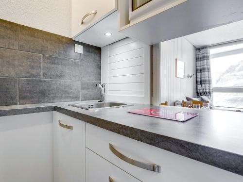 a kitchen with white cabinets and a sink at Apartment Les Origanes-3 by Interhome in Les Menuires