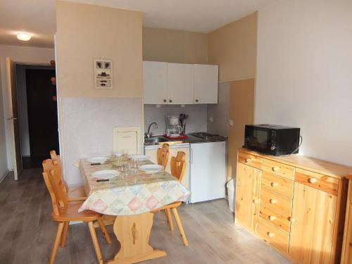 une cuisine avec une table et des chaises dans une cuisine dans l'établissement Apartment Asters 804 Bâtiment C5 by Interhome, aux Menuires