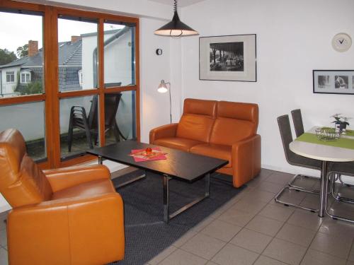 uma sala de estar com um sofá, uma mesa e cadeiras em Apartment Strandvilla - LUB111 by Interhome em Lubmin