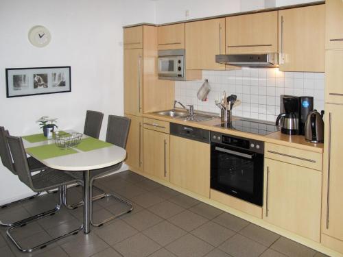 eine Küche mit einem Tisch und einem Herd Top-Backofen in der Unterkunft Apartment Strandvilla - LUB111 by Interhome in Lubmin