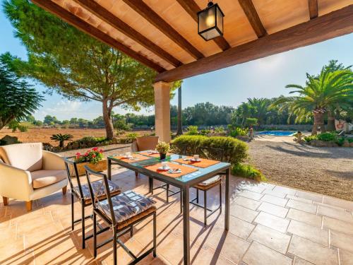 a patio with a table and chairs under a wooden pergola at Holiday Home Morla - PSR130 by Interhome in Porreres