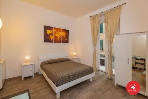 1 dormitorio con 1 cama, 2 mesas y una ventana en Affittacamere Il Viaggiatore, en La Spezia