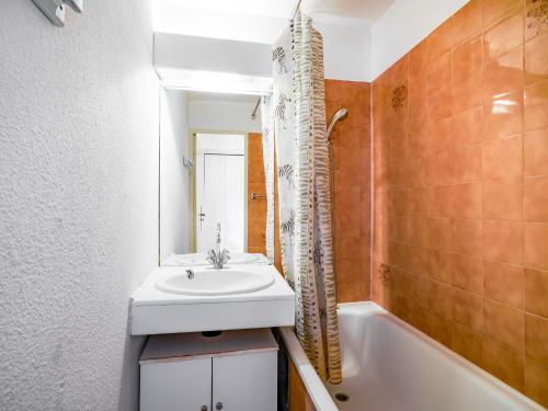 une salle de bain avec un lavabo, un miroir et une baignoire dans l'établissement Apartment Le Centaure by Interhome, au Cap d'Agde