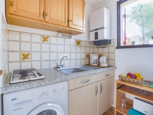 a kitchen with a washing machine and a sink at Apartment Le Centaure by Interhome in Cap d'Agde