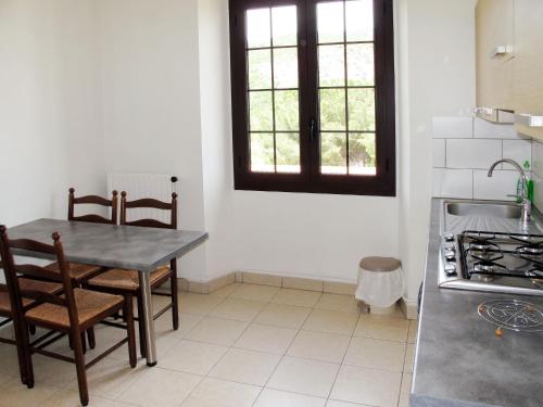 a kitchen with a table and chairs and a sink at Apartment L'Aghja Nova - GAL106 by Interhome in Galeria