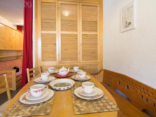a wooden table with cups and saucers on it at Apartment Le Curling B-7 by Interhome in Tignes