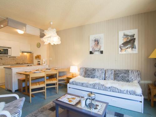 a living room with a couch and a table and a kitchen at Apartment Le Curling B-27 by Interhome in Tignes