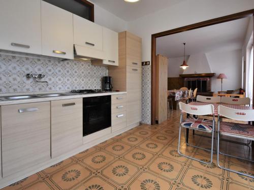 - une cuisine avec des placards blancs, une table et des chaises dans l'établissement Apartment Villa Martinelli-2 by Interhome, à Crone