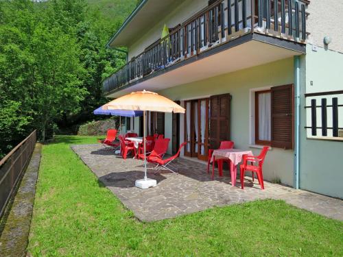 a patio with tables and chairs and an umbrella at Apartment Villa Martinelli-2 by Interhome in Crone