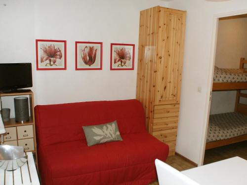 ein Wohnzimmer mit einem roten Sofa und einem Etagenbett in der Unterkunft Apartment Les Joncioles by Interhome in Samoëns