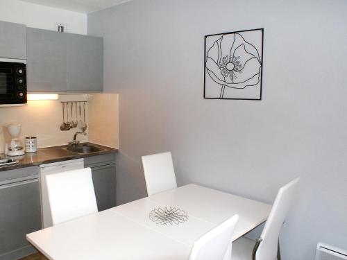 a kitchen with a white table and white chairs at Apartment Les Joncioles by Interhome in Samoëns