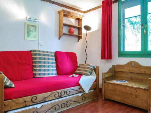 a living room with a red couch and a window at Studio Le Grépon-3 by Interhome in Chamonix