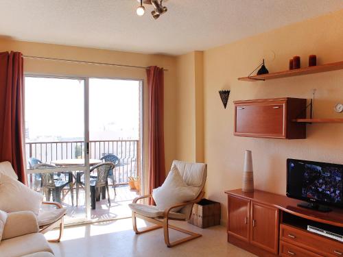 uma sala de estar com um sofá, uma televisão e uma varanda em Apartment Las Cinco Torres by Interhome em El Campello