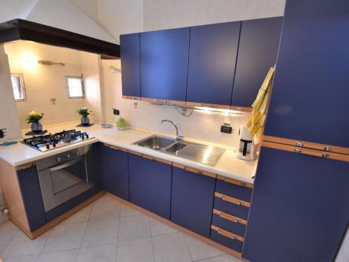 una cucina con armadi blu e lavandino di Apartment Al Foghèr by Interhome a Venezia