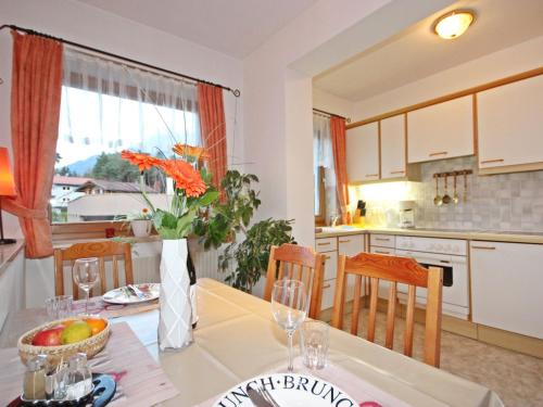 uma cozinha e sala de estar com uma mesa com uma taça de fruta em Apartment Bichleregg by Interhome em Sautens