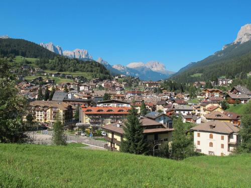 a town on a hill with mountains in the background at Apartment Cincelli - Latemar by Interhome in Pozza di Fassa