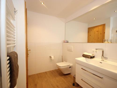 a white bathroom with a toilet and a sink at Holiday Home Seekarblick by Interhome in Achenkirch