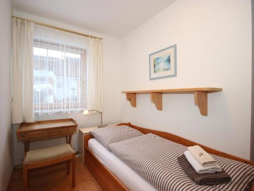 a bedroom with a bed and a desk and a window at Holiday Home Seekarblick by Interhome in Achenkirch