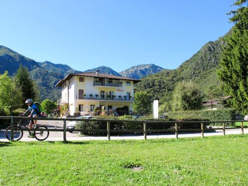 a person riding a bike in front of a building at Apartment Emilio-4 by Interhome in Ledro