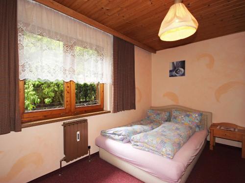 a bedroom with a couch in front of a window at Holiday Home Hussl by Interhome in Fügenberg