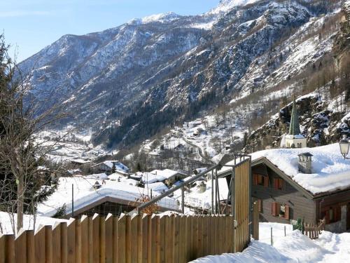una casa en la nieve con una valla y una montaña en Apartment Plen Solei by Interhome, en Valtournenche