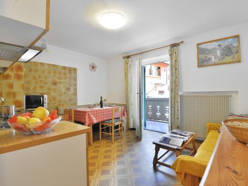 uma cozinha e uma sala de estar com uma mesa em Apartment Maura-2 by Interhome em Pozza di Fassa
